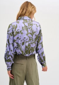Camicia a maniche lunghe verde e lavanda con motivi astratti, dotata di colletto e maniche a polsino, realizzata in tessuto morbido.
