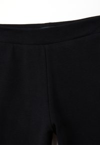 Zwarte leggings gemaakt van gladde stretchstof, met een elastische tailleband en een eenvoudig design zonder zakken of versieringen.