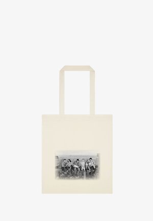 Canvas tote bag i beige med et frontgrafik af fem personer, der sidder på en bjælke, med en skyline i baggrunden, glat tekstur og robuste håndtag.
