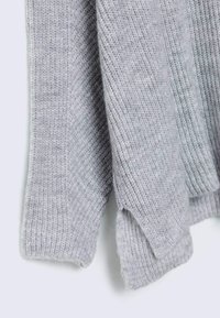 Light gray knitted sweater featuring a textured rib pattern, wide cuffs, and soft fabric with a slightly loose fit.
