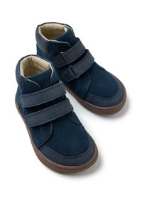 Zapatillas altas de color azul marino, hechas de ante y con suela de goma. Presentan dos correas de Velcro y un suave forro beige.