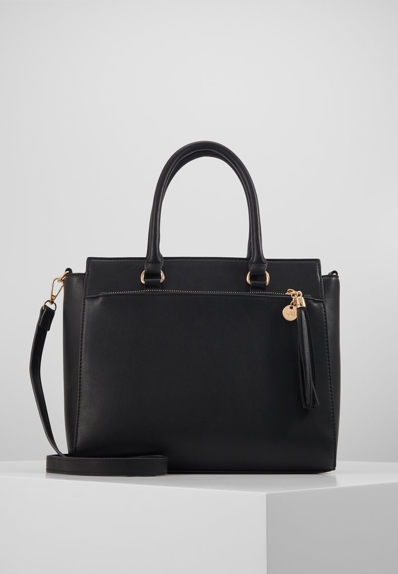 Borsa a mano in pelle nera con hardware dorato, doppi manici, tracolla rimovibile e una tasca con zip frontale con un accento a frange.
