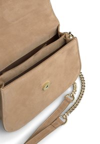 Beige suède handtas met een magneetsluiting, binnencompartimenten en een gouden kettingriem. Glad oppervlak en eenvoudig ontwerp.