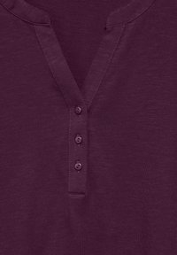 Short-sleeve, dark purple henley shirt with a V-neck, three buttons down the front, and a smooth texture.