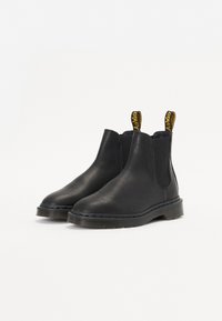 Zwarte Chelsea boots van glad leer, met elastische panelen, treklussen en een duurzame rubberen zool met een gestructureerde rand.