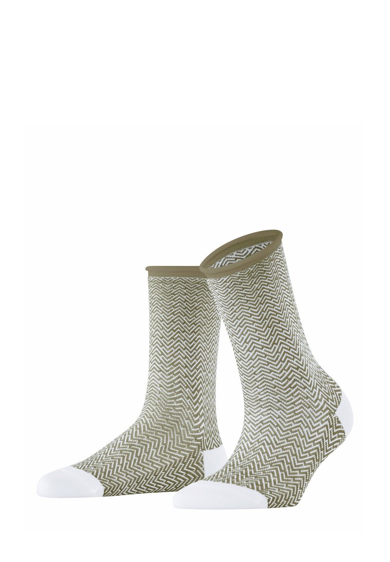 Olivgrüne Socken mit einem weißen Zickzackmuster, ausgestattet mit weißen Akzenten an Zehen und Ferse sowie einem gerippten Bündchen oben.