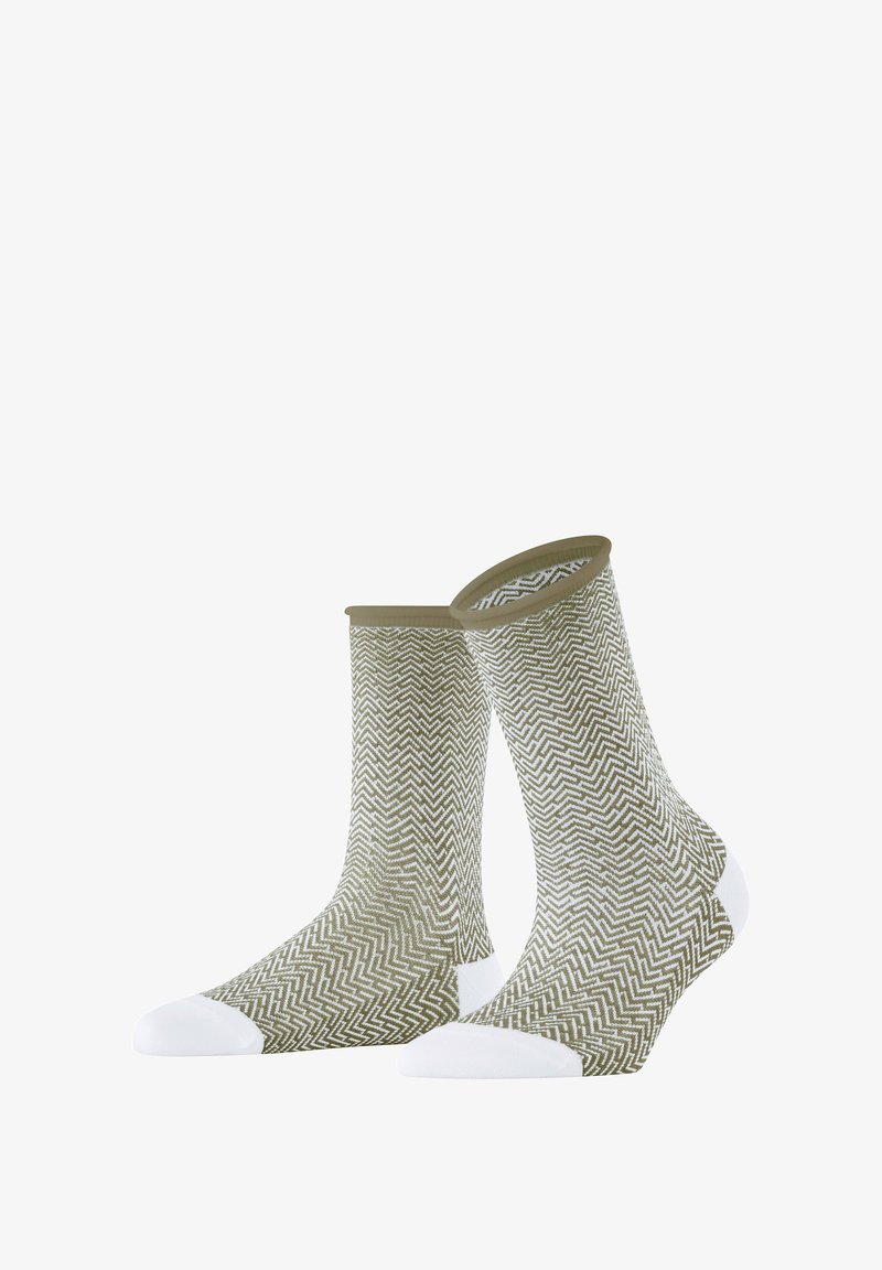 Olivgrüne Socken mit einem weißen Zickzackmuster, ausgestattet mit weißen Akzenten an Zehen und Ferse sowie einem gerippten Bündchen oben.