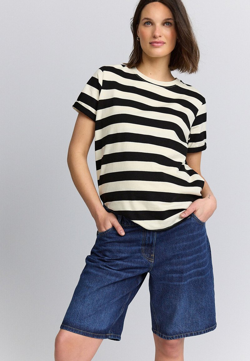 Sort og cremefarvet T-shirt med striber og korte ærmer, kombineret med blå denimshorts. Stoffet er blødt, og shortsene har en afslappet pasform.