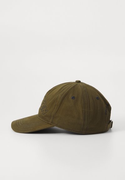 Gorra de béisbol verde oliva con tejido texturizado, acentos cosidos y una tira ajustable en la parte trasera. Presenta una marca en la parte frontal.