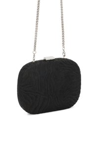 Melnā clutch soma ar teksturētu virsmu, ovāla forma un metāla sudraba ķēdes siksna. Cieši aizverama ar sprādzi un ar maigu reljefu apdruku.