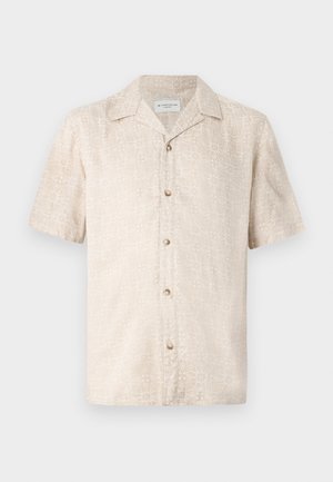 Korte mouwen, beige shirt met een subtiel bloemenpatroon en vijf knopen aan de voorkant, gemaakt van lichte stof.