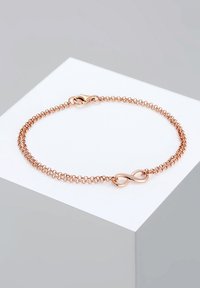 Armband aus Roségold mit feiner Kette und einem Infinity-Symbol als Mittelpunkt. Verfügt über einen Karabinerverschluss und eine glatte Metalloberfläche.