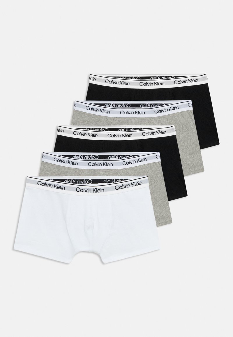 Πέντε ζευγάρια ανδρικά boxer Calvin Klein σε μαύρο, γκρι και άσπρο, τοποθετημένα αλληλεπικαλυπτόμενα σε ένα ανοιχτό φόντο.