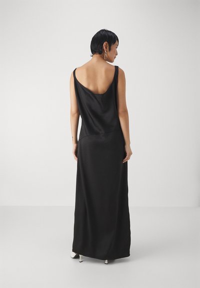 Rochie maxi din satin negru cu spate adânc și bretele late, având un croi lejer și o textură fină. Design simplu, elegant, fără accesorii.