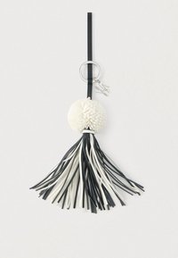 Črno-bela usnjena obesek za ključe z okroglo teksturirano cofko in srebrnim obročem, pritrjenim na črn trak.