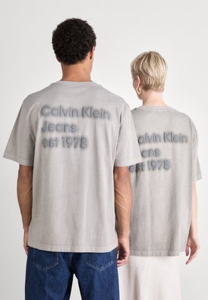 Gray cotton t-shirts with short sleeves, featuring "Calvin Klein Jeans est 1978" printed in a subtle, raised design on the back.