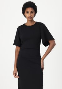 Black fitted dress with short puff sleeves, round neckline, and gathered side detail. Made of smooth, stretchy fabric.