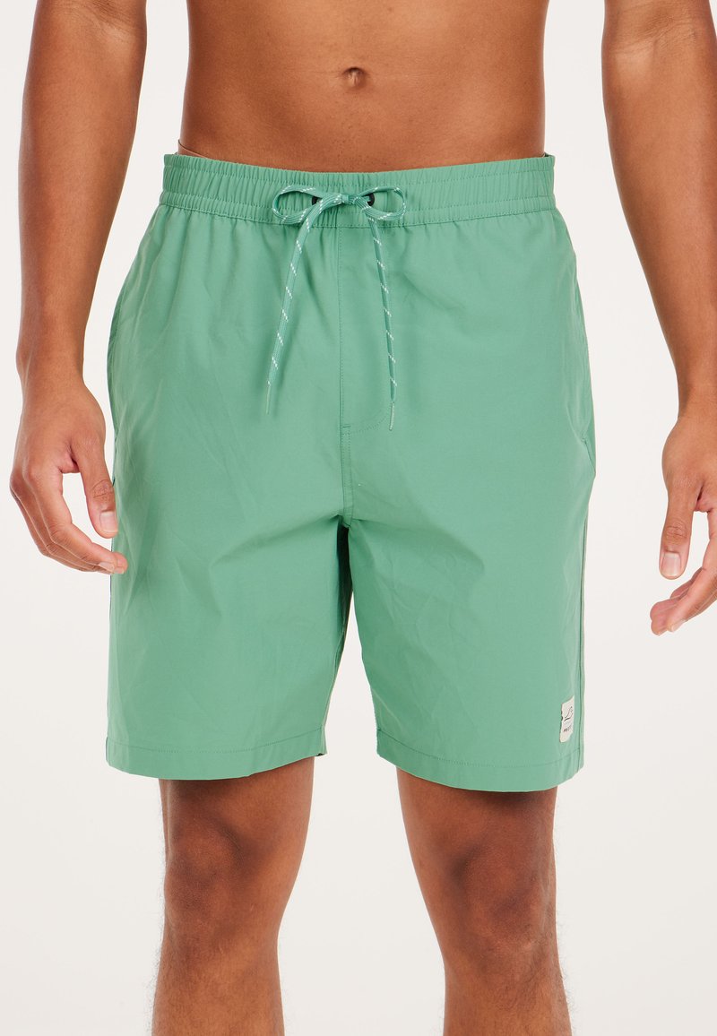 Groene zwembroek met een elastische tailleband en koord. Gladde textuur, lengte boven de knie, met een klein logopatch.