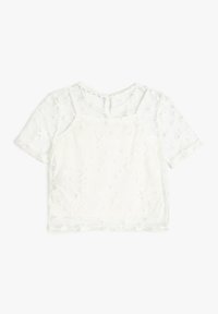 Top bianco a maniche corte con sovrapposizione trasparente, caratterizzato da un motivo a stelle e un collo rotondo. Completato con chiusura a bottone sul retro.