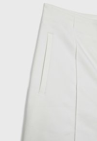 Gonna di tessuto bianco con una texture liscia, forma dritta e due tasche laterali senza hardware o decorazioni visibili.