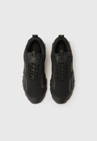 Μαύρα αθλητικά παπούτσια με υφασμάτινο άνω μέρος με υφή, επενδεδυμένο περιλαίμιο και λαστιχένια σόλα. Διαθέτουν κορδόνια και λογότυπο στη γλώσσα.