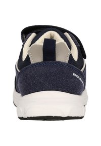 Marineblaue Sportschuhe mit einem strukturierten Obermaterial aus Stoff, kontrastierenden cremefarbenen Akzenten, verstellbarem Riemen und einer weißen Gummisohle.