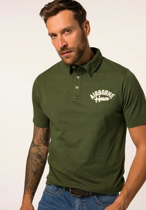 Polo de color verde oliva con collar clásico, tapeta de tres botones y estampado blanco de "AIRBORNE HERO". Fabricado en algodón con mangas cortas.