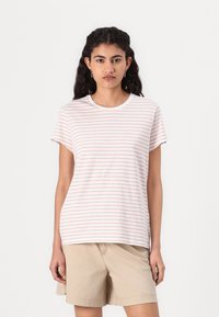 Stripete T-skjorte i lys rosa og hvit, korte ermer, rund hals, mykt bomullstoff; parret med beige shorts.