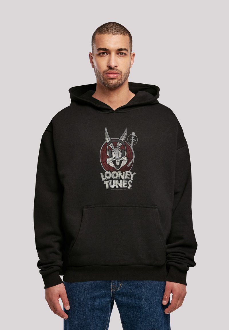 Svart hettegenser med Looney Tunes grafikk. Mykt materiale, avslappet passform, kengurulomme og ribbestrikkede mansjetter.