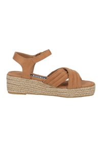 Tan platform sandals with a rope-woven base, featuring cross-straps and an adjustable ankle strap for securing fit. Soft-textured upper.