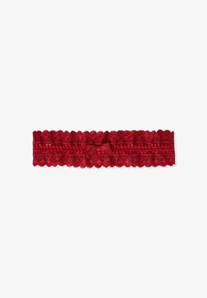 Garter in pizzo rosso con bordi ondulati e un piccolo fiocco di raso al centro, caratterizzato da un delicato motivo floreale sul tessuto.