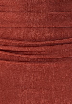 Rustt värvi kangas, millel on sooniline tekstuur ja horisontaalsed klapid, mis loovad kihilise detaili kangal.