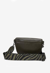 Bolso cruzado de cuero verde oliva con una textura suave, que presenta una correa ajustable de rayas de cebra en negro y oliva y una apertura con cremallera.