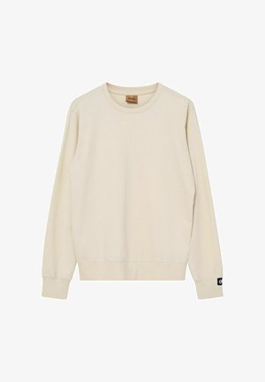 Krémszínű, hosszú ujjú, kerek nyakú pulóver bordázott mandzsettákkal és szegéllyel, jobboldali ujjmandzsettán kis fekete logócímkével.