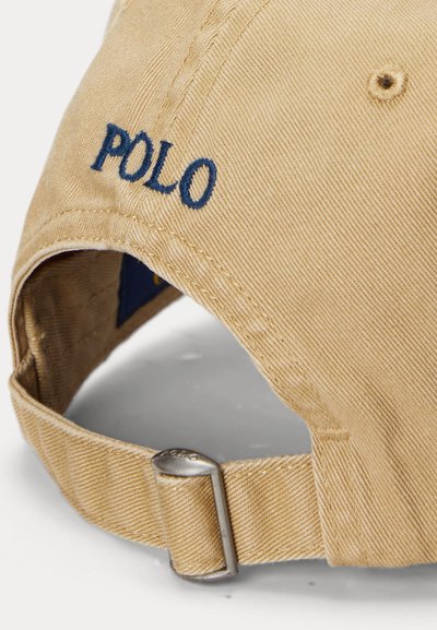 Cappellino da baseball beige con cinturino regolabile e fibbia in metallo, logo "POLO" ricamato in blu sul pannello posteriore.