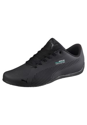 Czarny tenis Puma z perforowanym wzorem, czarnymi sznurowadłami i małym logo zespołu AMG Petronas Formula One po boku.