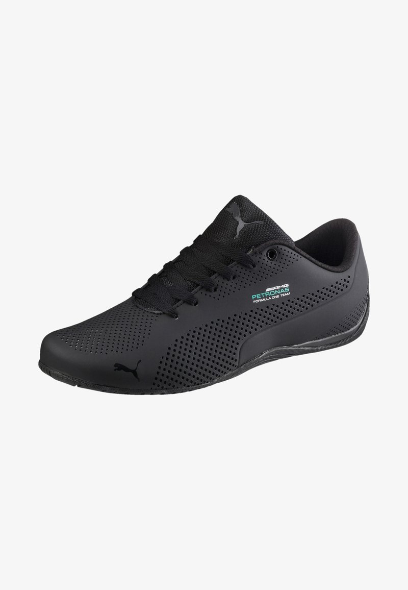 Baskets Puma noires avec un design perforé, des lacets noirs et un petit logo de l'équipe AMG Petronas de Formule 1 sur le côté.