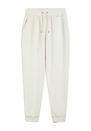 Ecru zwężane spodnie dresowe z elastycznym paskiem w talii, sznurkiem do ściągania, bocznymi kieszeniami i ściągaczami przy kostkach, z małą metalową metką marki.