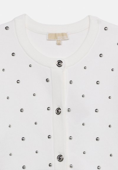 Valge kootud kardigan ümmarguse kaelusega, hõbedaste nööpidega kinnitamiseks ja esiküljel tihendatud metallist helmeste kaunistustega.