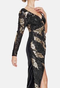 Black sequined dress with gold floral patterns, long sleeves, a deep V-neckline, and a thigh-high slit. Textured fabric adds dimension.
