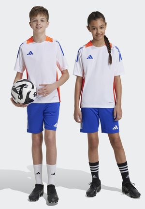 Camisetas deportivas blancas y naranjas con pantalones cortos azules, tacos negros y calcetines en contraste; con el logo de Adidas y detalles de diseño.