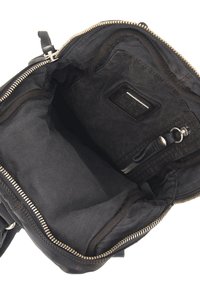 Interno di una borsa a mano in tessuto nero con una tasca con zip, texture liscia e forma rettangolare. Presenta una zip in metallo e un'etichetta con il marchio.