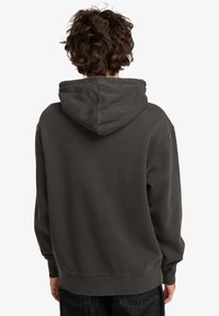 Dark gray pullover hoodie with a drawstring hood, ribbed cuffs, and hem. Features a soft texture and relaxed silhouette. Back view shown.