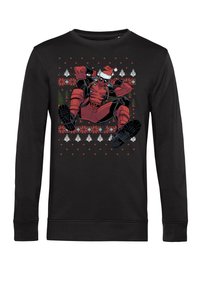 Sudadera negra de manga larga con un estampado gráfico en rojo y negro de un personaje con un gorro de Navidad, rodeado de patrones navideños.