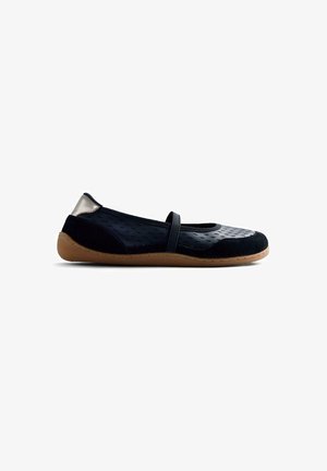 Zapato plano negro con parte superior texturizada, banda elástica y suela de caucho natural. Con un acento metálico en el talón.