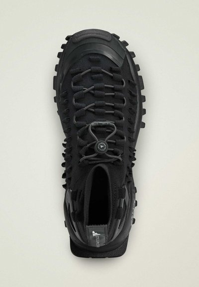 Scarpa da ginnastica nera con tomaia in knit testurizzato, sistema di allacciatura innovativo, suola in gomma resistente e punta rinforzata.