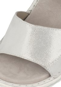 Sandalo grigio con una larga fascia in rete argentata sopra una morbida soletta in suede, con una suola ammortizzata e cuciture dettagliate lungo i bordi.