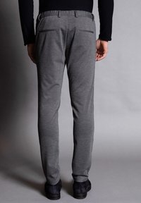 Grå avsmalnande byxor med elastisk midja, som har två bakfickor, en slät yta och en klassisk design.