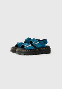 Sandale suede albastre cu talpă din cauciuc negru, având două curele reglabile și catarame din metal, evidențiate prin cusături galbene.