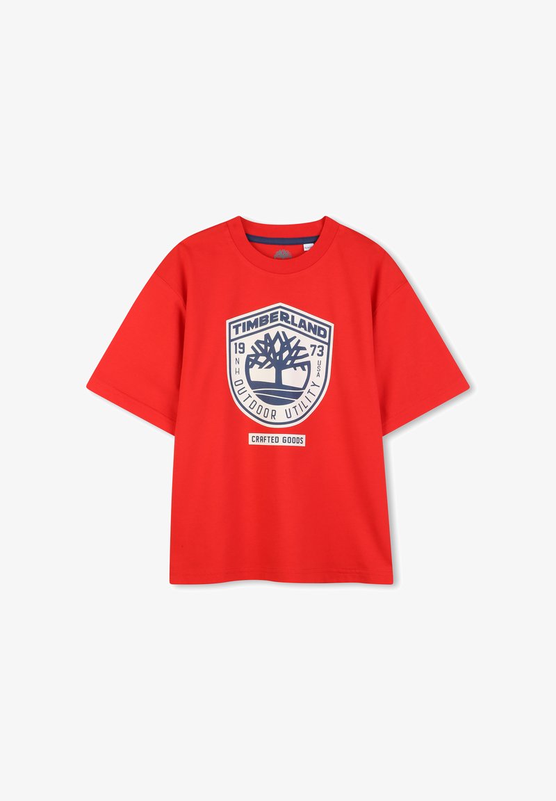 T-shirt en coton rouge à manches courtes, avec un grand logo graphique bleu, comprenant le texte "TIMBERLAND" et un emblème d'arbre.